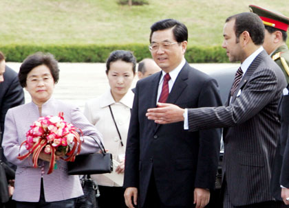 China's President Hu Jintao (C) and his wife Liu Yongqing (L) are welcomed by Moroccan King Mohammed in Rabat April 24, 2006. Hu kicked off a three-nation tour of Africa in Morocco on Monday, boosting already booming ties to a continent rich in the energy and minerals his country needs to feed a fast-growing economy.