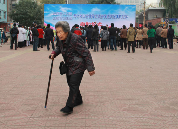 An elderly woman walks through a square during a launch ceremony for a health service for married couples whose only child has died in Taiyuan, Shanxi province, in October. The couples receive medical services from local family planning and health authorities. PROVIDED TO CHINA DAILY Lawmakers consider support system for elderly with one child