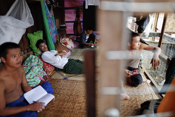 Residents pass the time at their 4m by 2m (13ft by 6ft) cell, where they are moved as punishment for breaking rules, at 'The Light of The World' rehabilitation centre for heroin addicts in Myitkyina, the capital of Myanmar's Kachin state July 6, 2013.  Myanmar's heroin addicts resort to religion's help